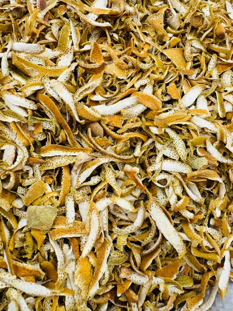 Sliced dried orange peels in bulk, golden and evenly cured